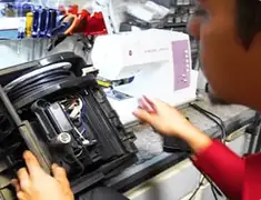 Vacuum repair technician servicing internal components on a workbench in Long Beach, CA
