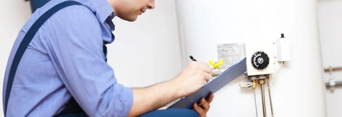Water heater repair technician inspecting the unit and recording service notes in Long Beach, CA